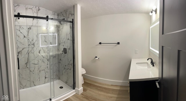 bathroom featuring vanity, a shower with shower door, wood-type flooring, and toilet