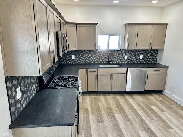 kitchen with sink, decorative backsplash, light wood-type flooring, and appliances with stainless steel finishes