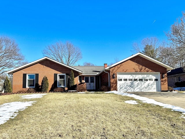 ranch-style home with a garage and a front lawn