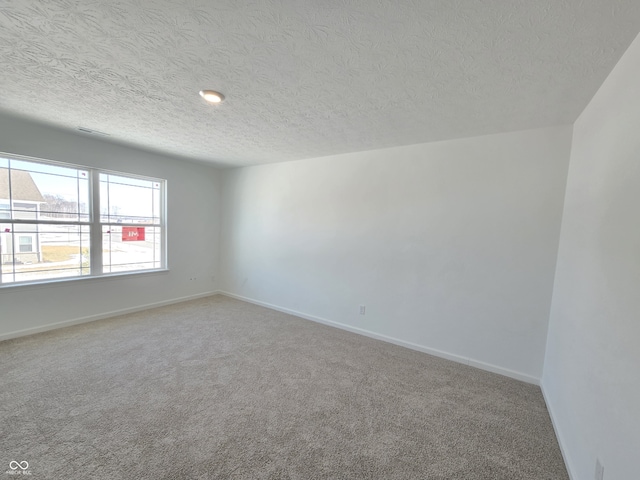 carpeted empty room with a textured ceiling