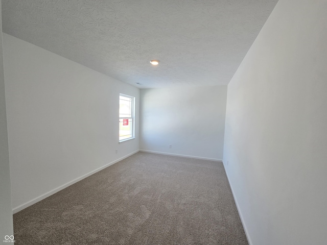 spare room featuring a textured ceiling and carpet flooring