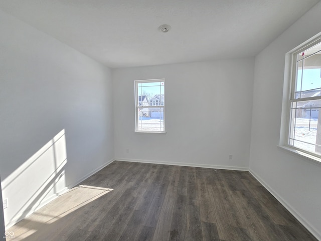 unfurnished room featuring dark wood-type flooring and plenty of natural light