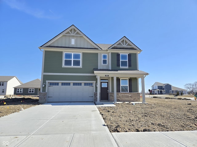 craftsman house featuring brick siding, board and batten siding, covered porch, a garage, and driveway