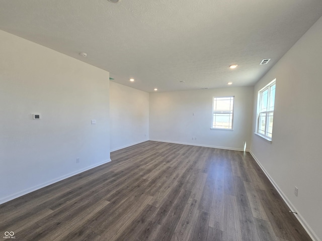 unfurnished room with recessed lighting, baseboards, visible vents, and dark wood-style flooring