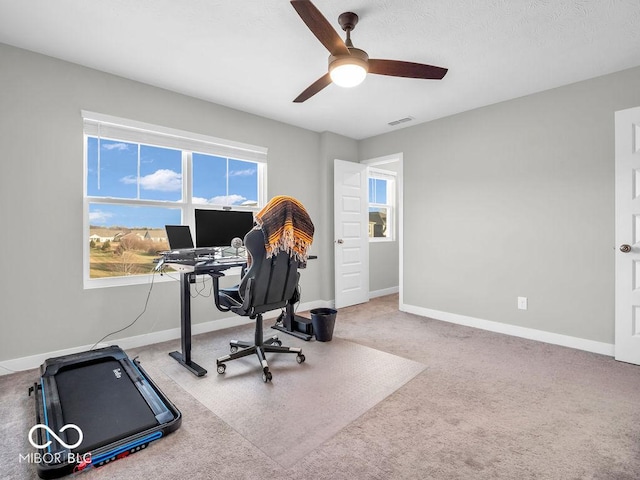 carpeted office space with ceiling fan