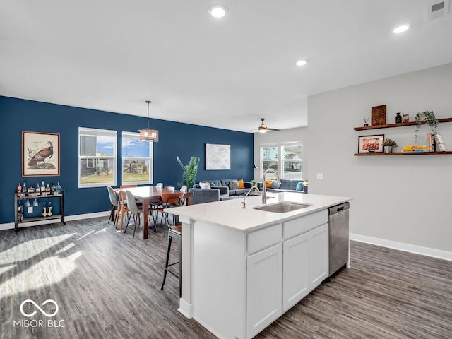 kitchen featuring sink, white cabinetry, decorative light fixtures, dishwasher, and a kitchen island with sink