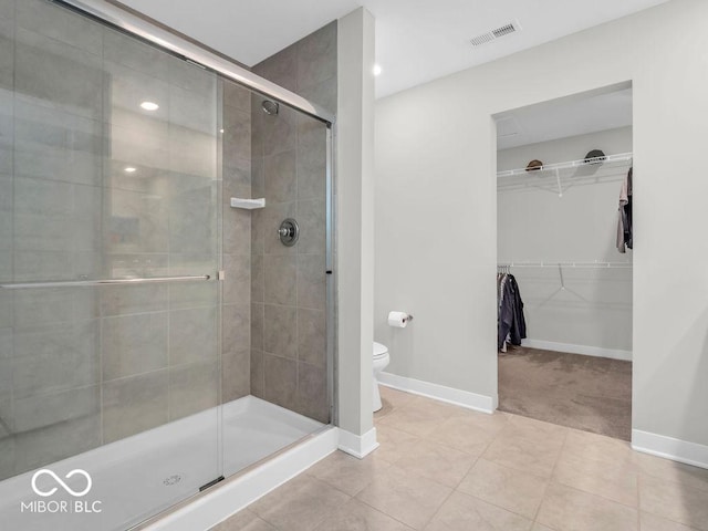 bathroom with an enclosed shower, tile patterned floors, and toilet