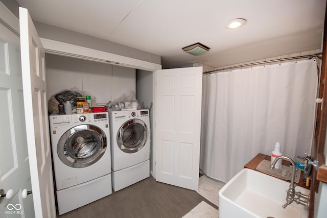 laundry area featuring sink, dark wood-type flooring, and washing machine and clothes dryer