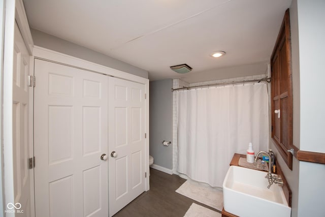 bathroom featuring toilet, curtained shower, and sink