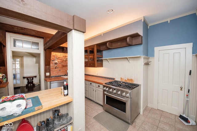 kitchen featuring white cabinetry, crown molding, appliances with stainless steel finishes, and wood counters