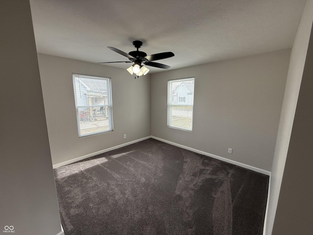 unfurnished room with dark carpet, a textured ceiling, and ceiling fan