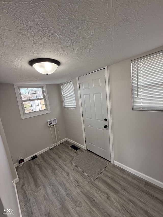 clothes washing area featuring hardwood / wood-style flooring, washer hookup, and a textured ceiling