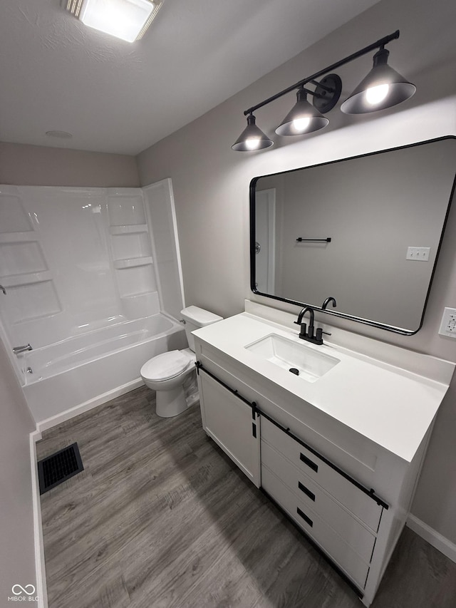 full bathroom with shower / tub combination, wood-type flooring, toilet, and vanity