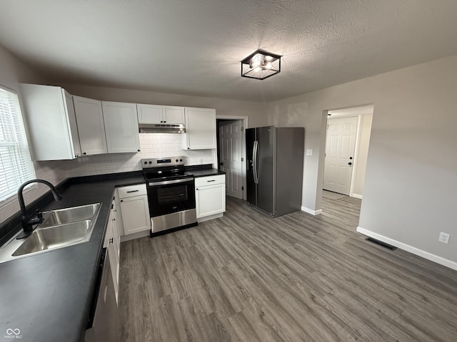 kitchen featuring sink, appliances with stainless steel finishes, dark hardwood / wood-style floors, white cabinets, and backsplash