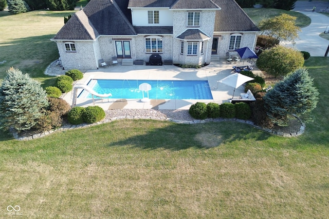 view of swimming pool with a yard, a patio, and a water slide