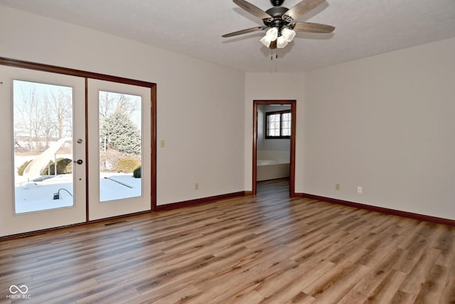 unfurnished room with ceiling fan, light hardwood / wood-style floors, and french doors