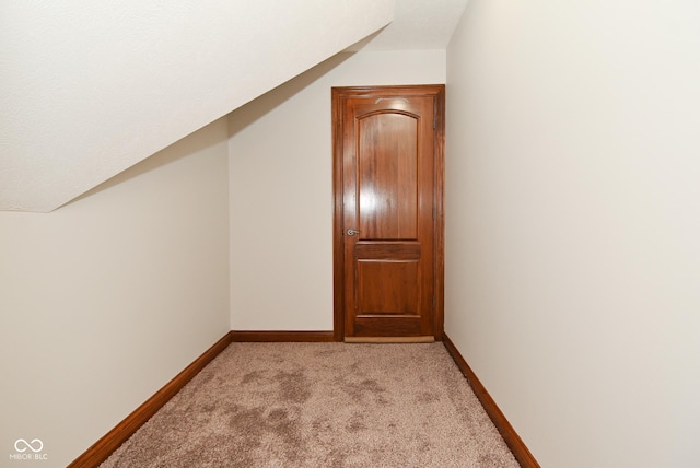 bonus room with lofted ceiling and light colored carpet