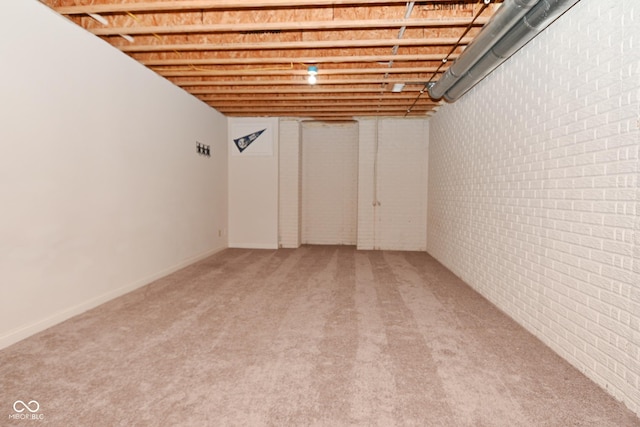 basement featuring brick wall and carpet floors