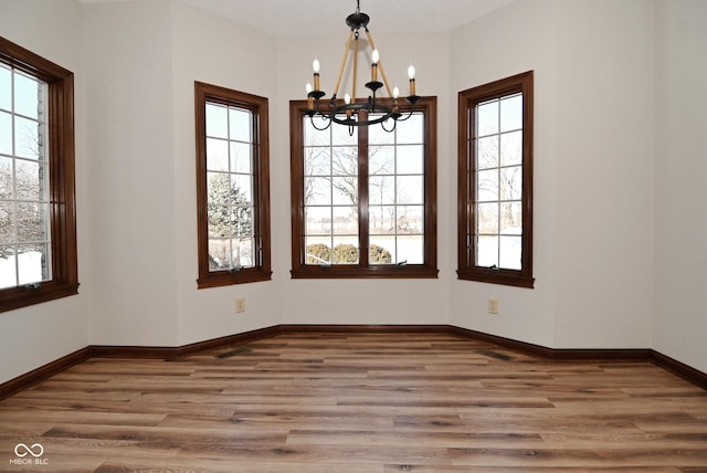 empty room featuring hardwood / wood-style floors and a chandelier