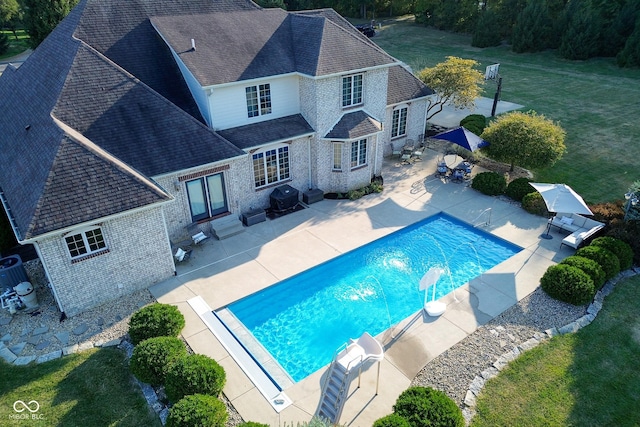 view of pool with area for grilling, a yard, and a patio area