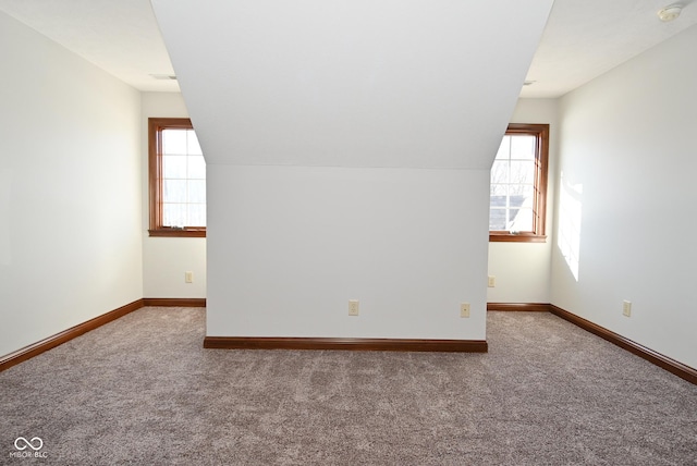 bonus room featuring lofted ceiling, plenty of natural light, and carpet flooring