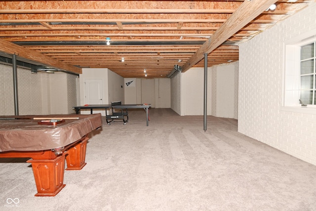 basement with brick wall, light colored carpet, and pool table