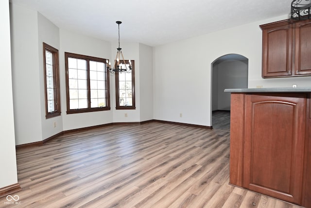 interior space with an inviting chandelier and light hardwood / wood-style floors