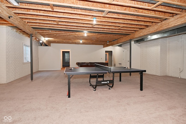 game room featuring light colored carpet and brick wall