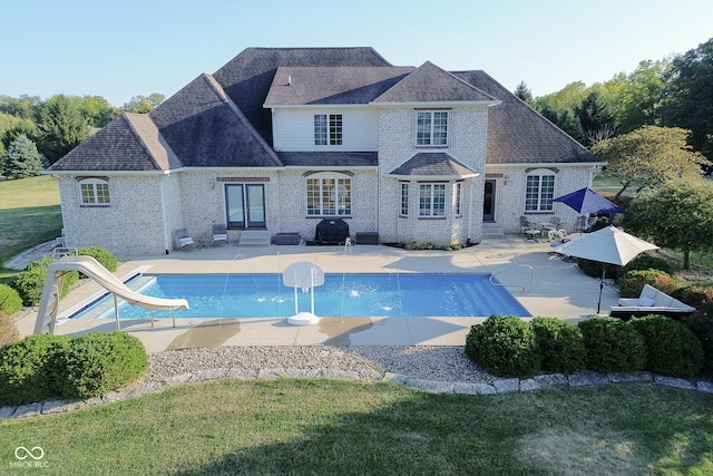 rear view of house featuring a lawn and a patio area