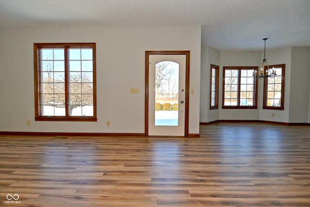 foyer entrance featuring an inviting chandelier and dark hardwood / wood-style floors