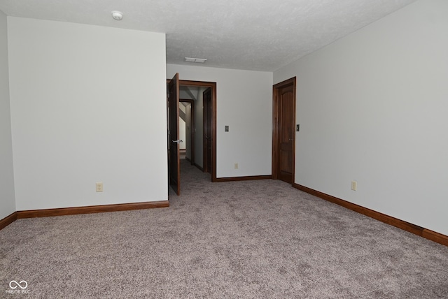 carpeted spare room featuring a textured ceiling