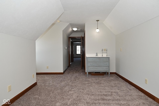 additional living space featuring dark colored carpet and vaulted ceiling