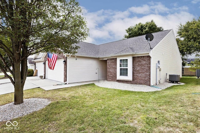 view of front of property with a garage, central AC, and a front lawn