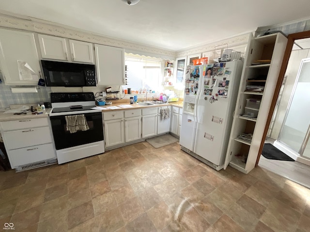 kitchen featuring white cabinetry, white refrigerator with ice dispenser, sink, and electric range