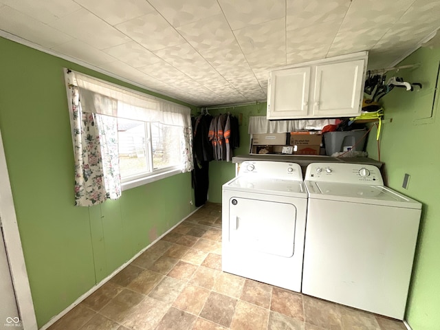 laundry area with independent washer and dryer and cabinets