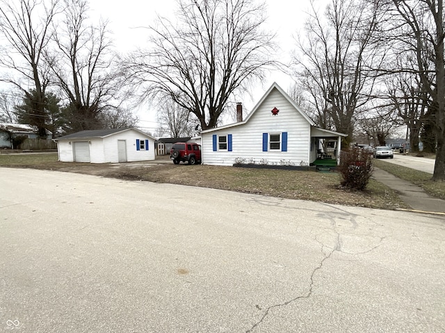 view of side of home featuring a garage, an outdoor structure, and a carport