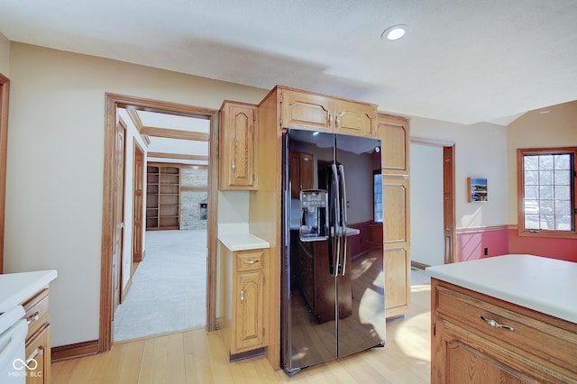 kitchen featuring black fridge, light brown cabinets, and light wood-type flooring