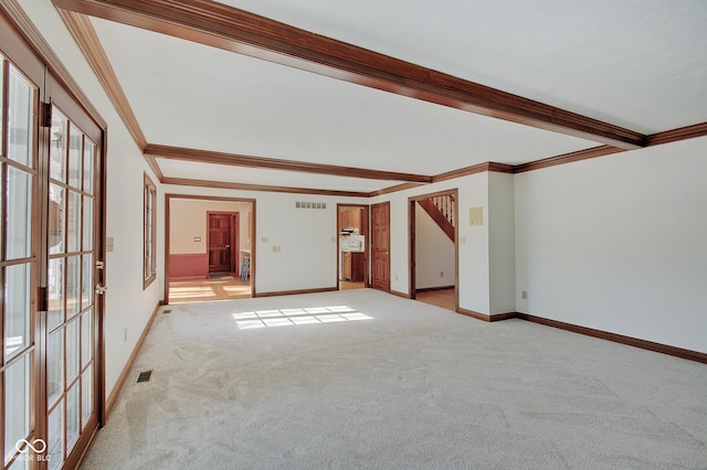 carpeted empty room with ornamental molding and beam ceiling