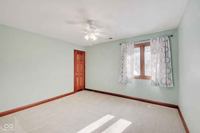 spare room featuring light carpet and ceiling fan