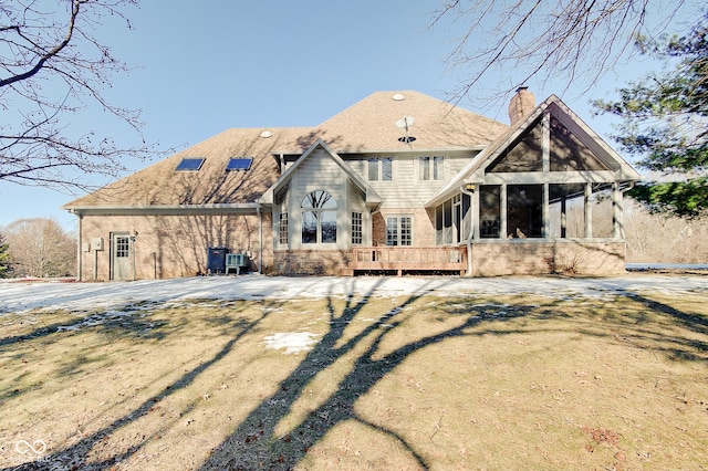 back of property with a yard and a sunroom