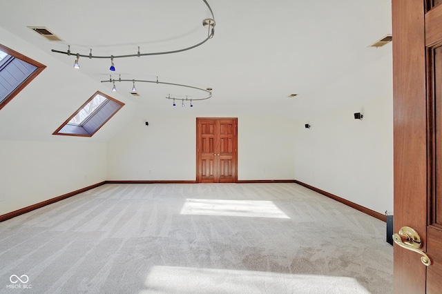 bonus room with vaulted ceiling with skylight and light colored carpet