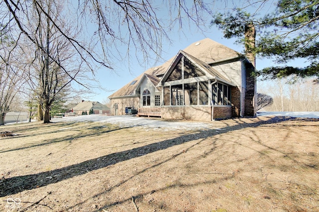 view of front of home with a sunroom and a front lawn