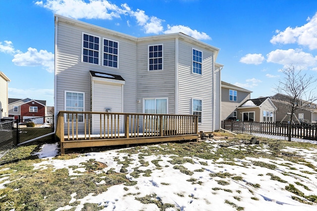 snow covered rear of property featuring a deck