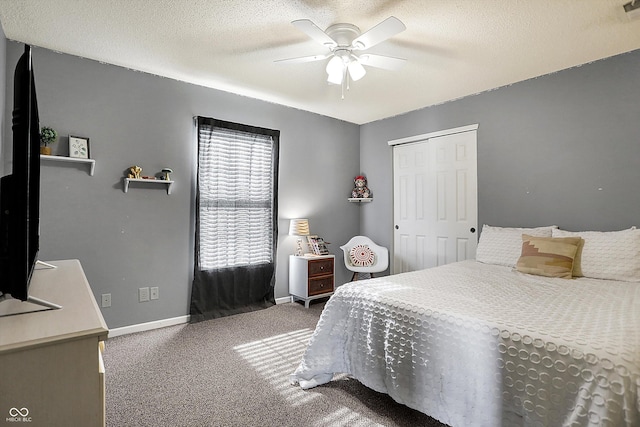 bedroom featuring ceiling fan, carpet floors, a closet, and a textured ceiling