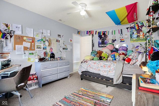 carpeted bedroom with ceiling fan and a textured ceiling