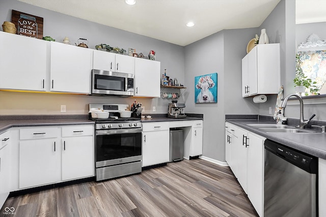 kitchen with white cabinetry, appliances with stainless steel finishes, sink, and light wood-type flooring