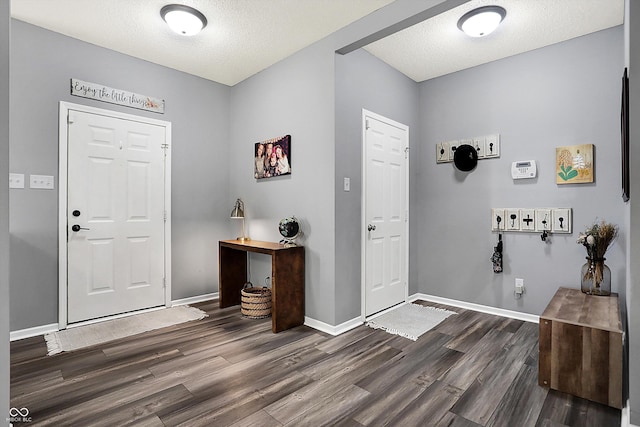 entrance foyer with dark wood-type flooring and a textured ceiling