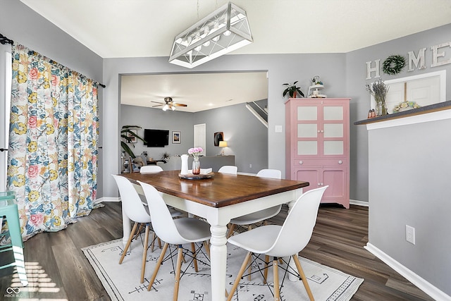 dining area with dark wood-type flooring and ceiling fan