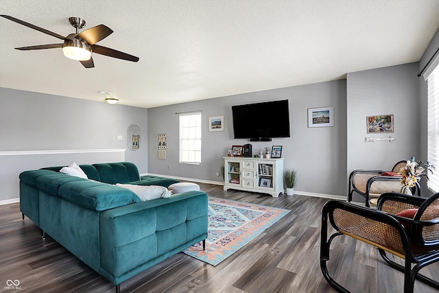 living room featuring ceiling fan, dark hardwood / wood-style floors, and a textured ceiling