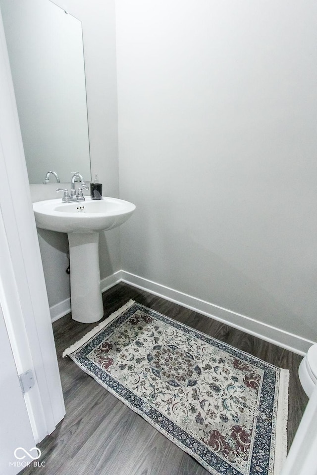 bathroom with wood-type flooring and toilet